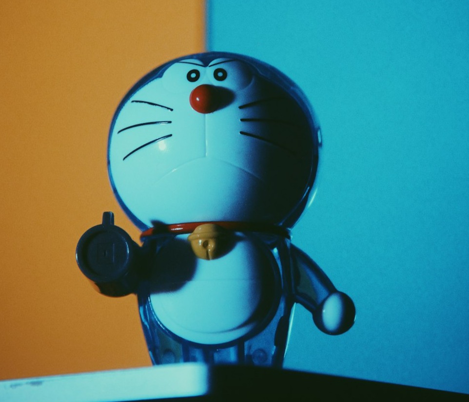 a cat figurine sitting on top of a laptop computer