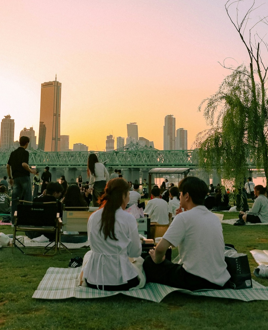 People enjoying a sunset picnic by the river
