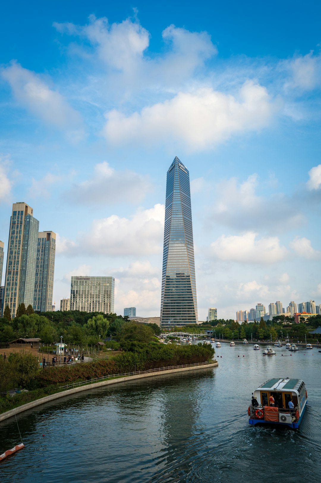 a boat traveling down a river in front of a tall building