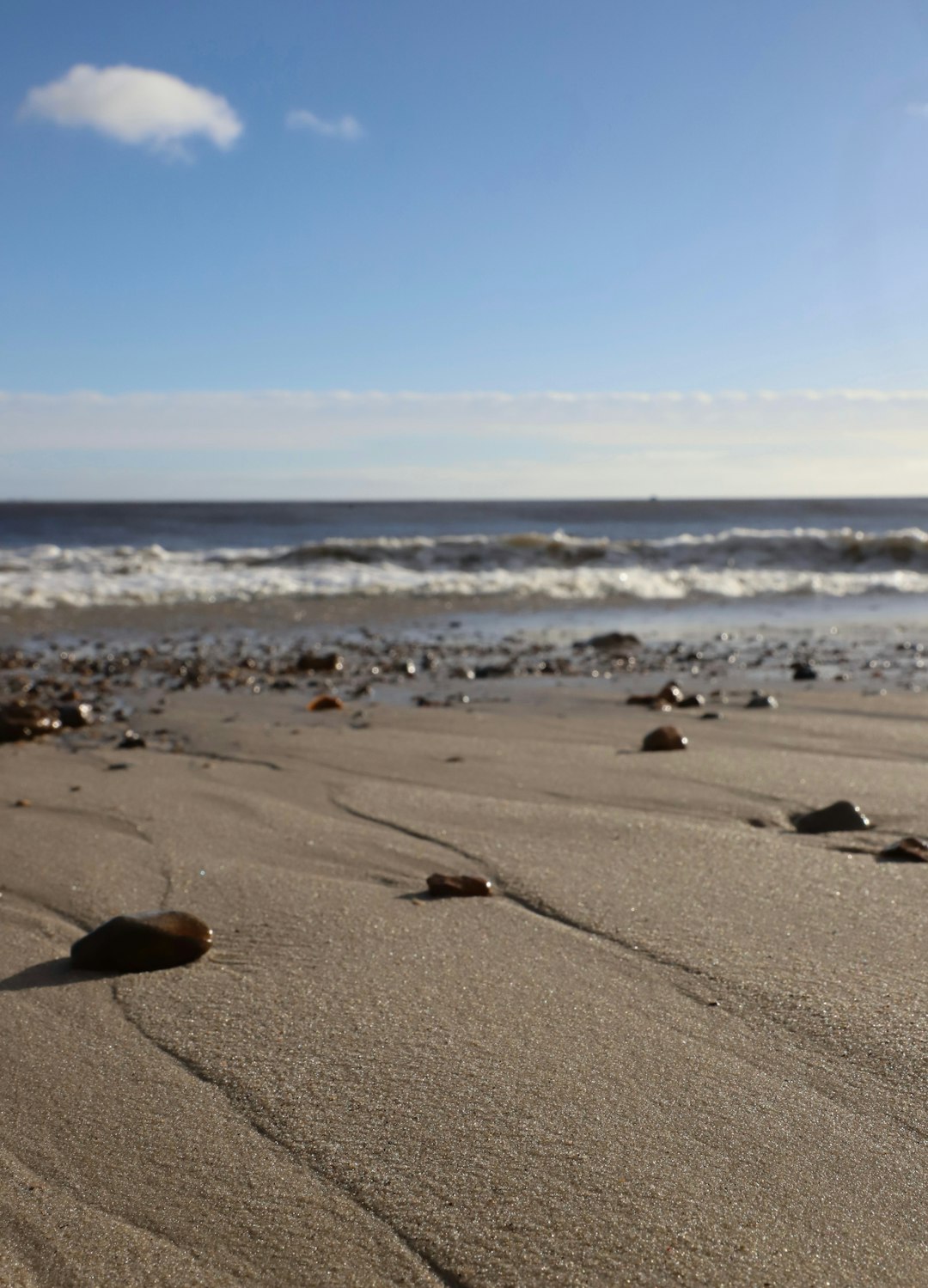Beach with sand, rocks, and ocean waves