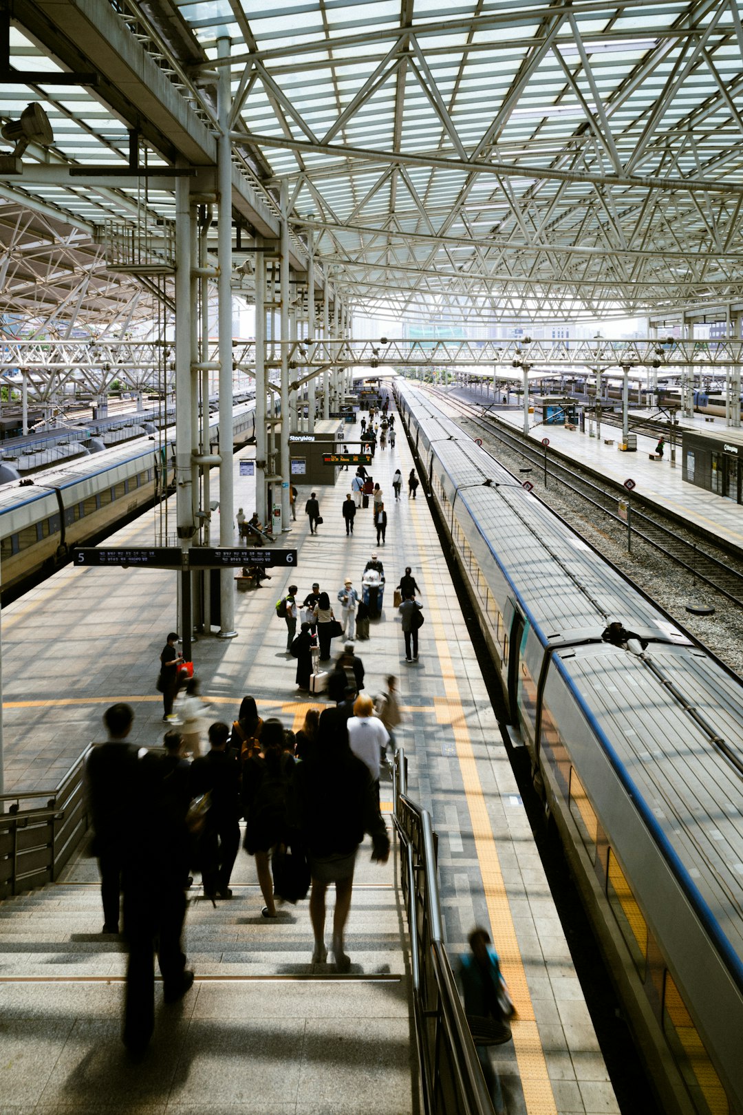 A group of people walking down a train platform