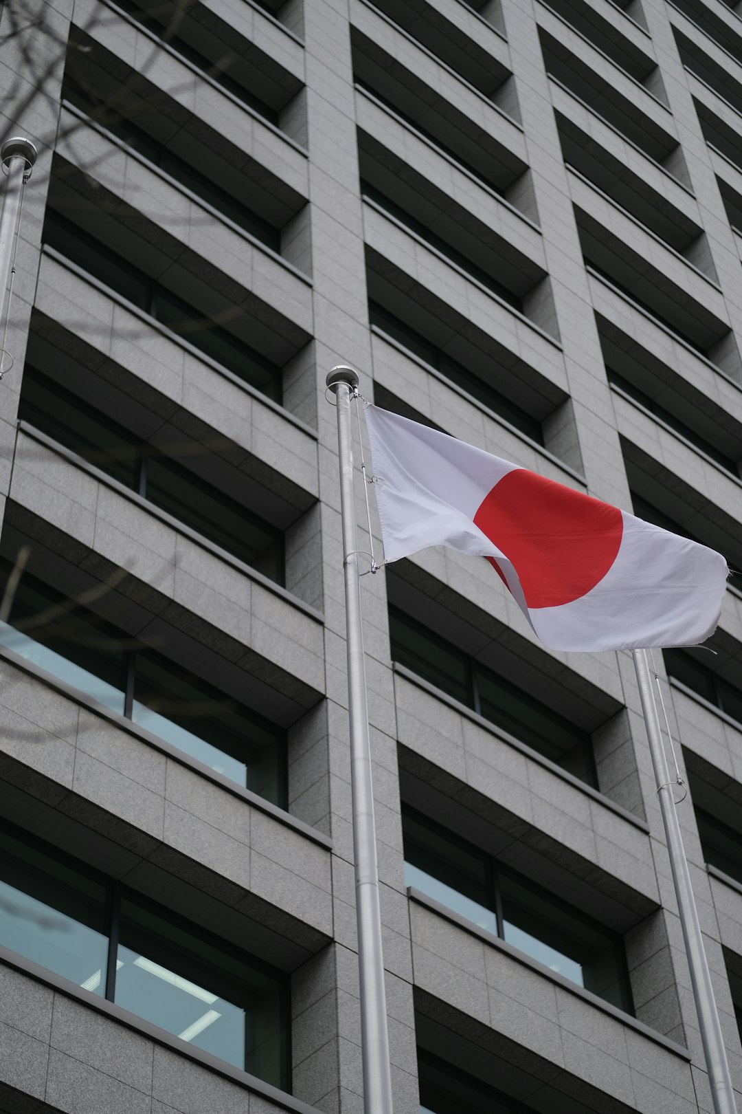 Japanese flag waving in front of a modern building