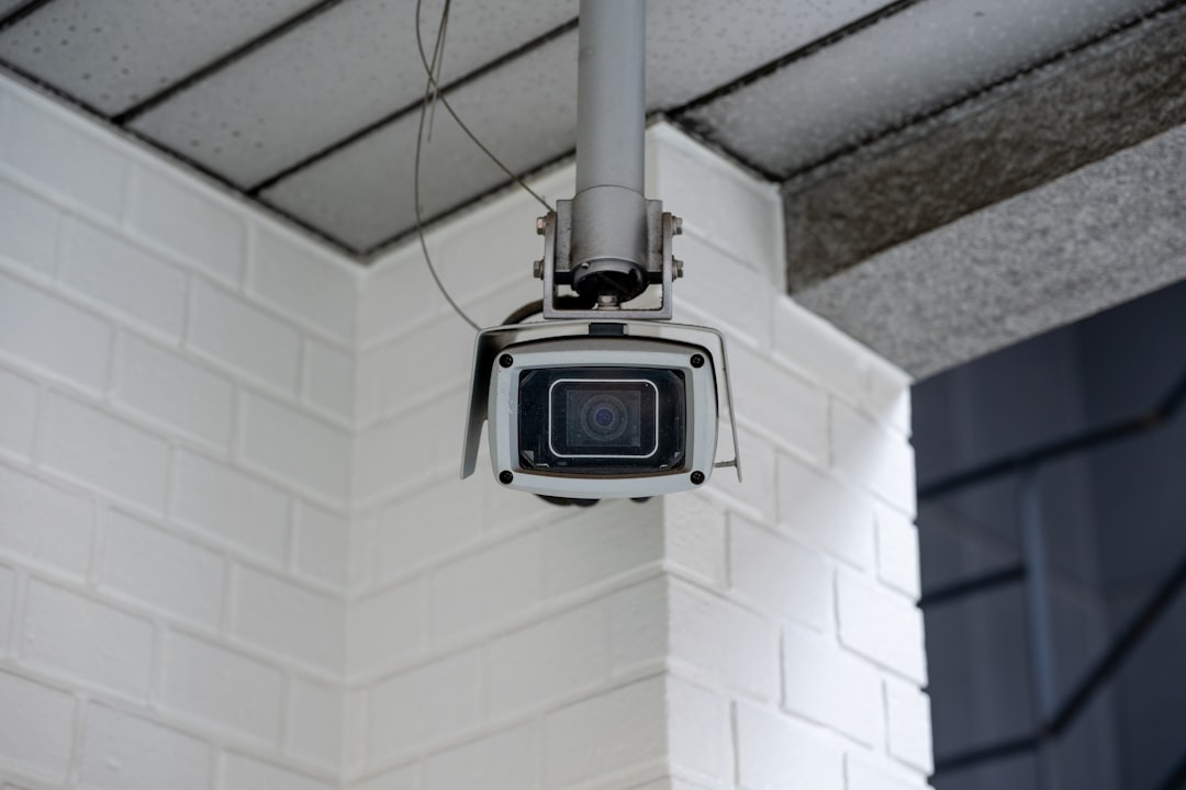 Security camera mounted on a white brick wall
