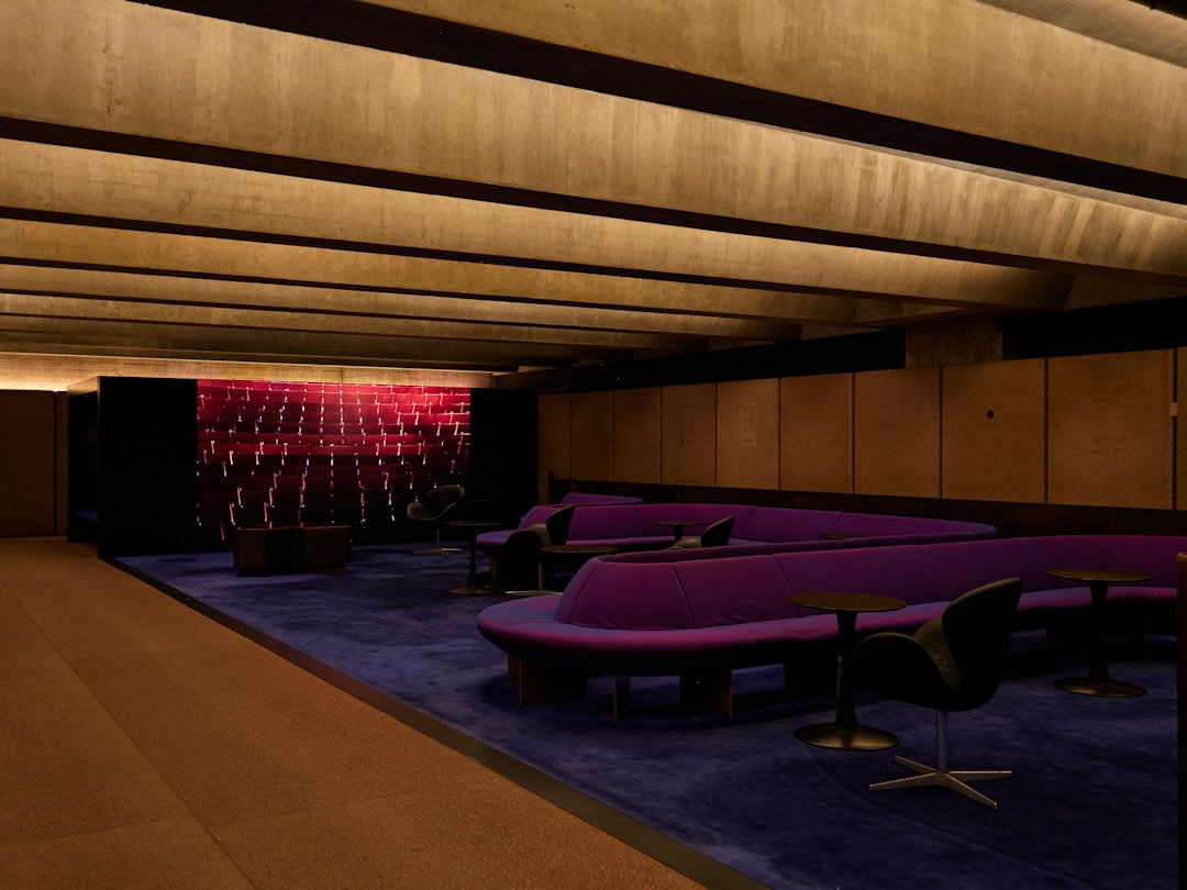 Stylish lounge area with curved purple seating and light wall