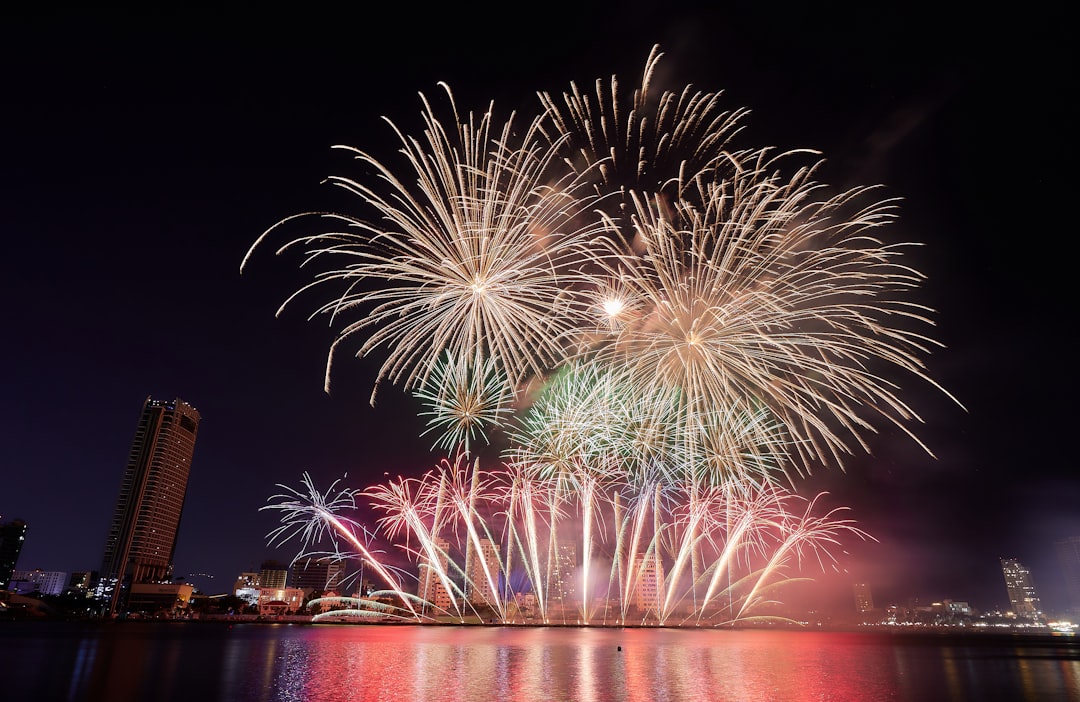 fireworks are lit up in the night sky over a body of water