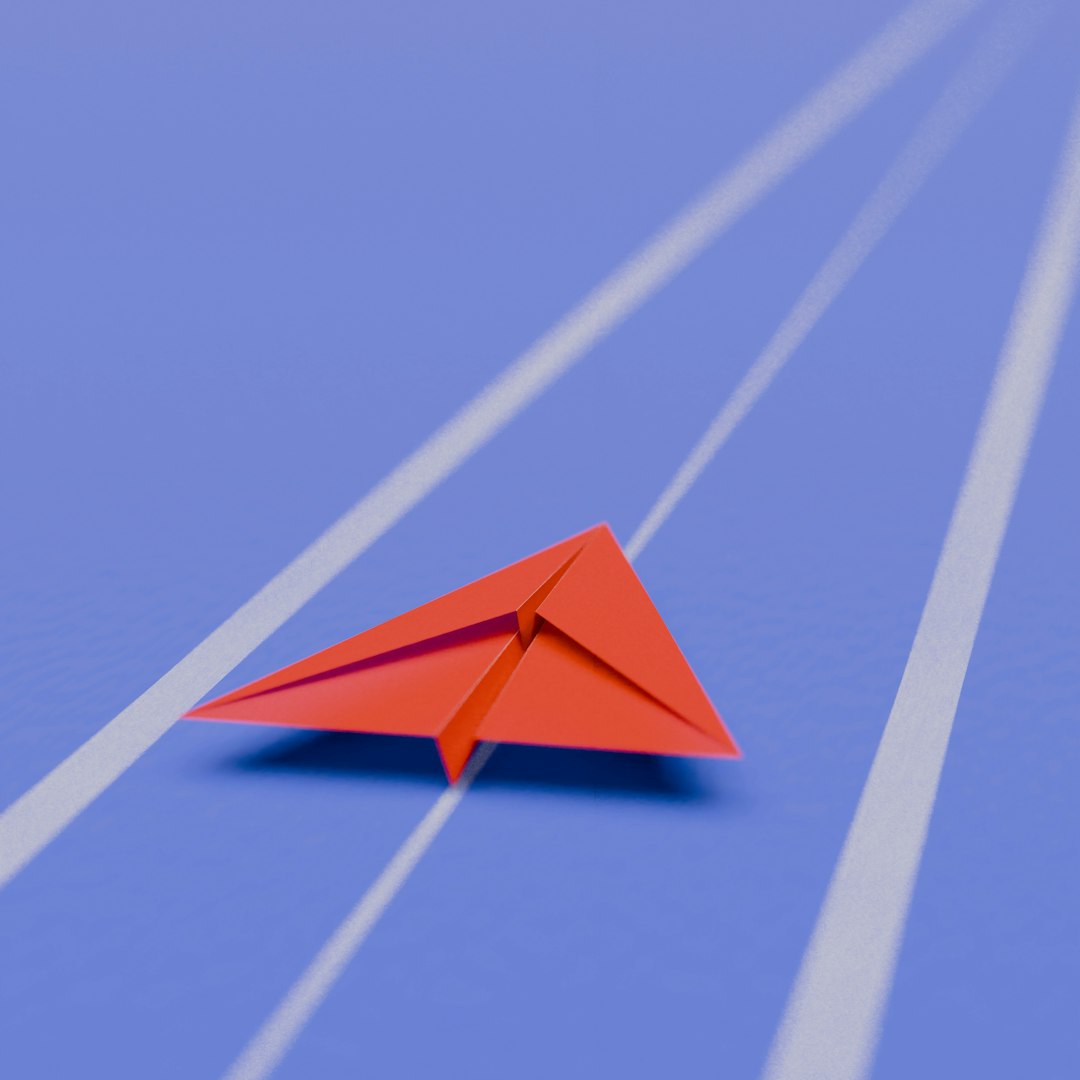 Red paper airplane on a blue track
