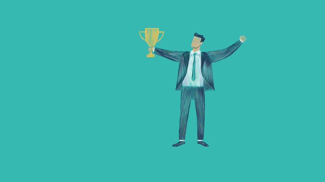 Man in suit holding a trophy with arms raised