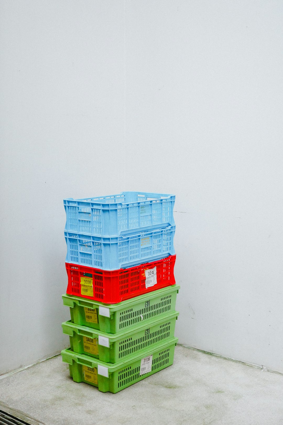 A stack of colorful plastic crates against a white wall