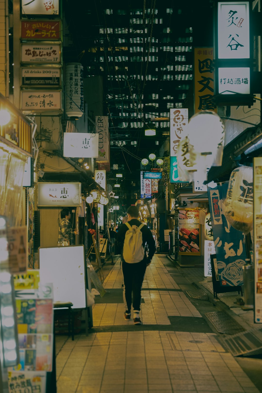 Person walks down a narrow street at night
